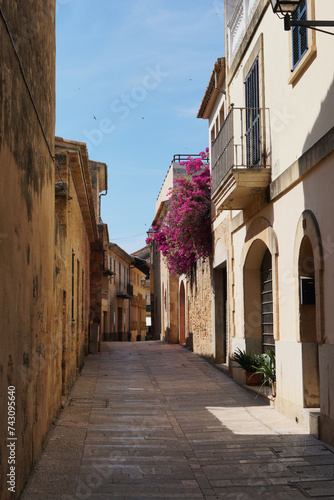 Narrow street in the old town. European  a deserted street in sunny weather. Spain  Majorca. Sandy and light beige houses.