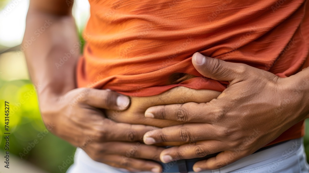 Man experiencing abdominal pain after exercising in the park, muscle injury and discomfort