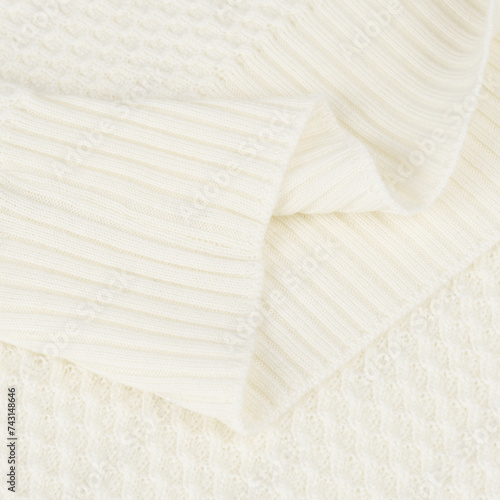Knitted elastic band on creamy white wool sweater close up