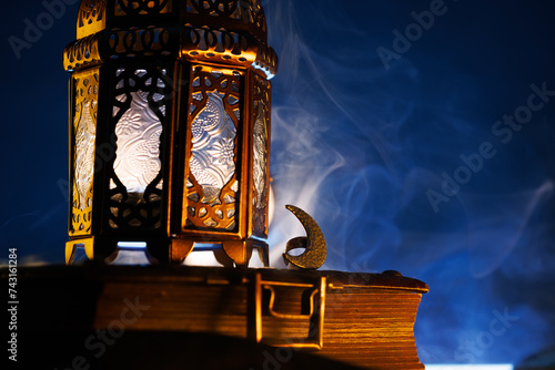 Ornamental Arabic lantern with burning candle glowing at night.Festive greeting card, invitation for Muslim holy month Ramadan Kareem.