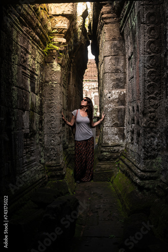 Tourist walking through the narrow corridors of the Angkor temples in Cambodia.