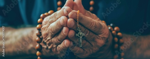 Woman hands holding a rosary and praying photo