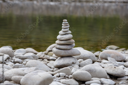 Obraz na płótnie Amazing round stone near a flowing river, Stones are perfectly balanced on one another and forming, These are river stones, or also buddha stones w salonie