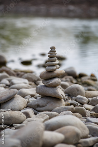 Obraz na płótnie Amazing round stone near a flowing river, Stones are perfectly balanced on one another and forming, These are river stones, or also buddha stones w salonie