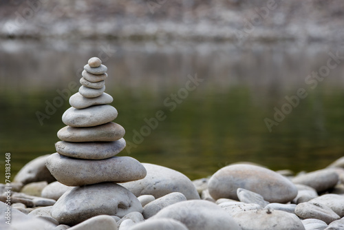Obraz na płótnie Amazing round stone near a flowing river, Stones are perfectly balanced on one another and forming, These are river stones, or also buddha stones w salonie