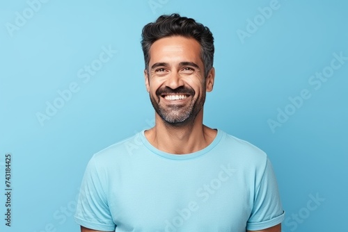 Portrait of handsome young man in blue t-shirt on blue background