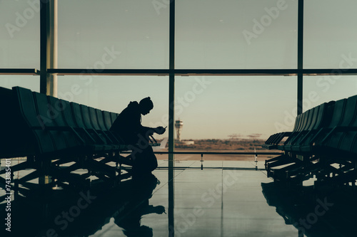 Silhouette of anonymous person waiting traveler at airport terminal photo