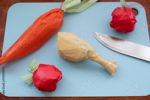 Plastic bags shaped like food items on a cutting board photo