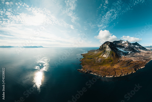 drone shot for breathtaking footage of wild nature in svalbard, majestic mountains in the clouds, massive river and nature under the cloud, useful for newspapers and magazines, travel to unspoiled 
