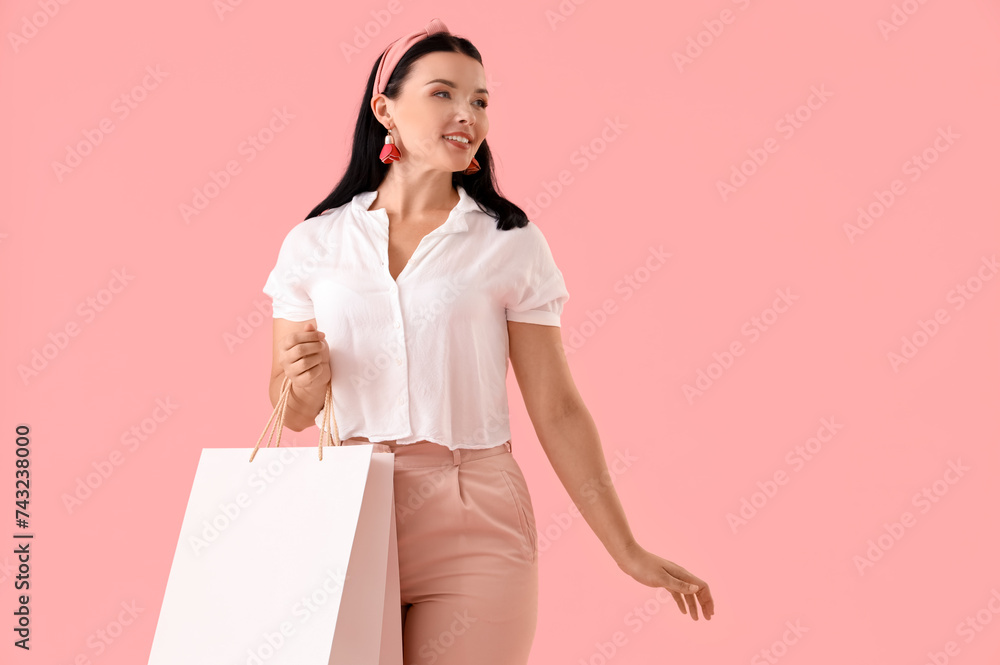 Portrait of happy young woman with shopping bag on pink background Portrait of happy young woman with shopping bag on pink background