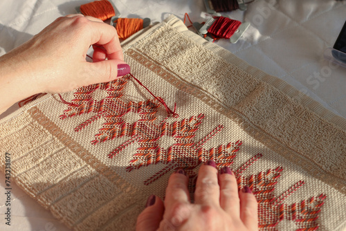 Close-up of woman embroidering on etamine fabric. Huck embroidery. 
