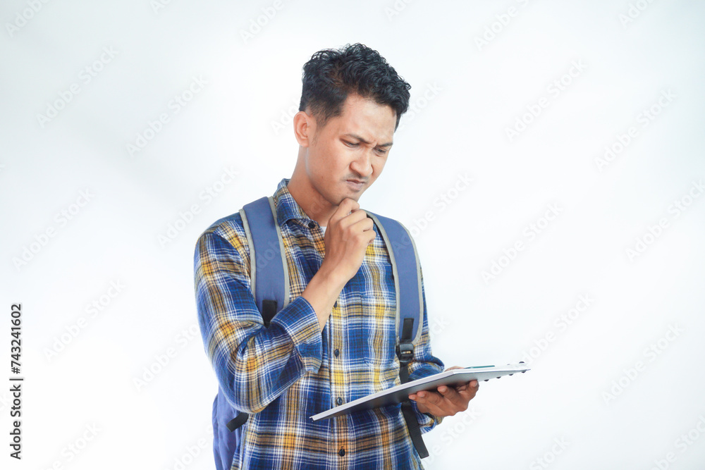 Concentrated young Asian students with backpacks in casual clothes enjoy reading books and thinking about the question and answer isolated on white background