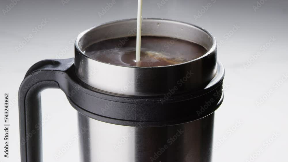 Pouring cream into a cup of coffee Pouring cream into a cup of coffee