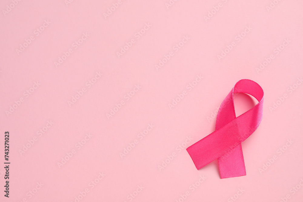 Pink ribbon on color background, top view and space for text. Breast cancer awareness