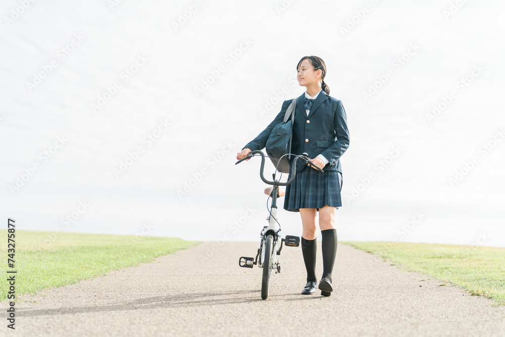Obraz premium 自転車で通学・登校・下校する制服姿の中学生・高校生（夢・希望・進路・道・将来・未来・青春・歩く） 