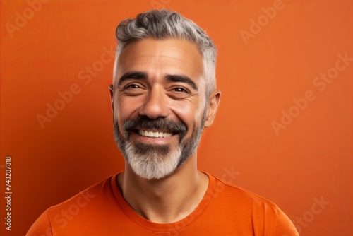 Portrait of a smiling middle-aged man over orange background. © Chacmool