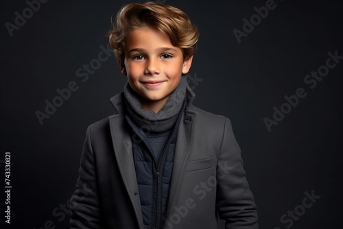 Portrait of a cute little boy in coat and scarf. Studio shot.