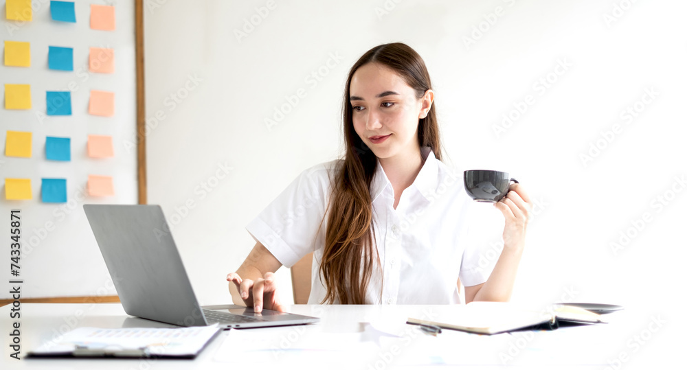 Asian businesswoman sit at their desks and calculate financial graphs showing results about their investments, planning a successful business growth process Asian businesswoman sit at their desks and calculate financial graphs showing results about their investments, planning a successful business growth process