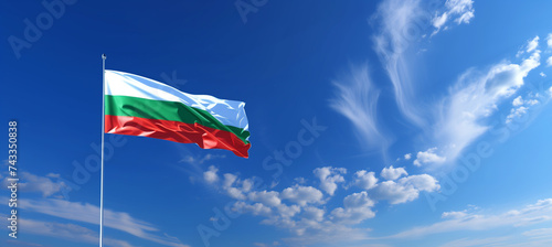 Fotografie National flag of bulgaria waving in the wind against a clear blue sky