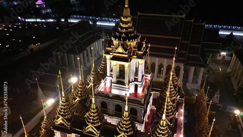 Aerial view of illuminated golden metal castle, Wat Ratchanatdaram Woravihara, Loha Prasat Temple at evening in Bangkok, Thailand photo