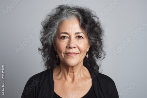 Portrait of a happy senior woman looking at the camera, on grey background