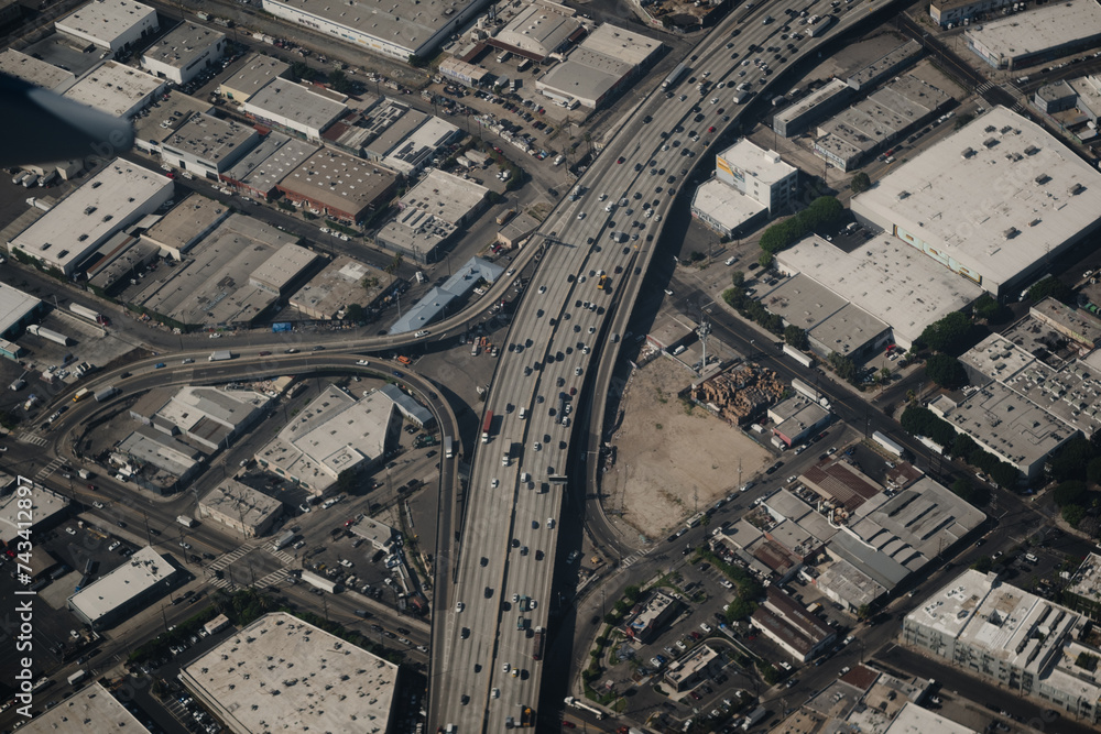 Aerial view of the 10 Freeway in Los Angeles, at the Alameda Street exit. It is a commercial area of LA, containing warehouses and industrial areas. Hundreds of cars move on the freeway. Aerial view of the 10 Freeway in Los Angeles, at the Alameda Street exit. It is a commercial area of LA, containing warehouses and industrial areas. Hundreds of cars move on the freeway.