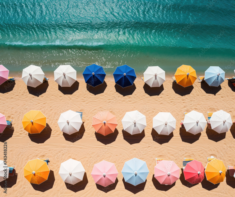 Overhead view of multiple colorful beach umbrellas open on the shoreline Overhead view of multiple colorful beach umbrellas open on the shoreline