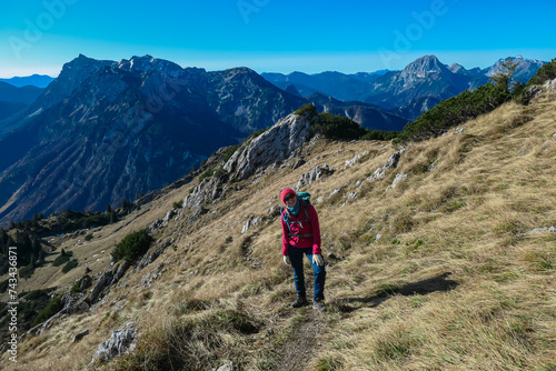 Hiker woman with scenic view of majestic mountain peaks of Gesäuse seen from Hochblaser in Eisenerz, Ennstal Alps, Styria, Austria. Idyllic hiking trail in remote nature in summer. Wanderlust concept © Chris