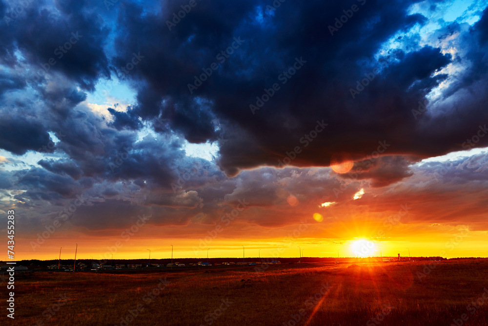 Obraz premium red sunset with clouds after rain in the steppe