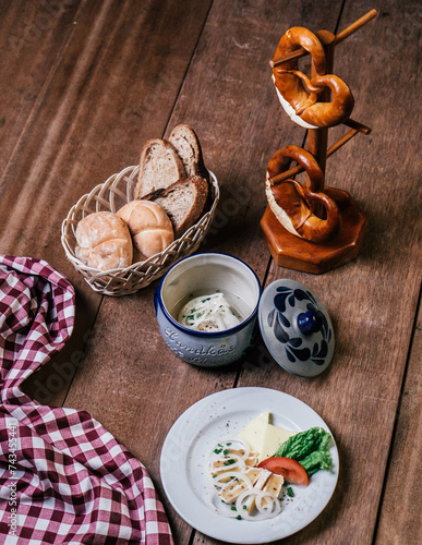 Fototapeta Naklejka Na Ścianę i Meble -  a plate of German cheese dish, with a basket of bread on a wooden table