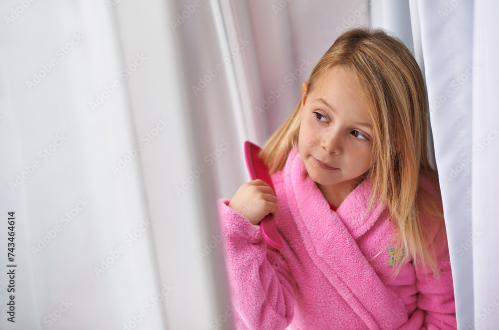 Child, hair and brush for morning routine in bathrobe for beauty grooming for getting ready, treatment or cosmetic. Girl, kid and comb in home apartment in London for style care, healthy or texture Child, hair and brush for morning routine in bathrobe for beauty grooming for getting ready, treatment or cosmetic. Girl, kid and comb in home apartment in London for style care, healthy or texture