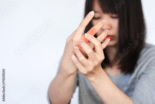 Woman has pain in her knuckles or hand from heavy use on white background.