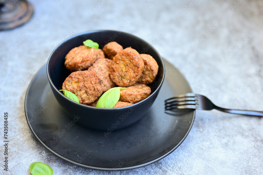 Home made oven baked meatballs from chicken and vegetables and french potato fries on wooden background.Bifteki, or spicy meatballs Home made oven baked meatballs from chicken and vegetables and french potato fries on wooden background.Bifteki, or spicy meatballs