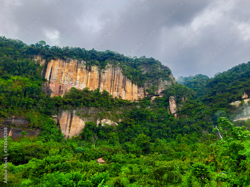 View of the Harau Valley filled with green plants with a backdrop of cloudy clouds in the morning