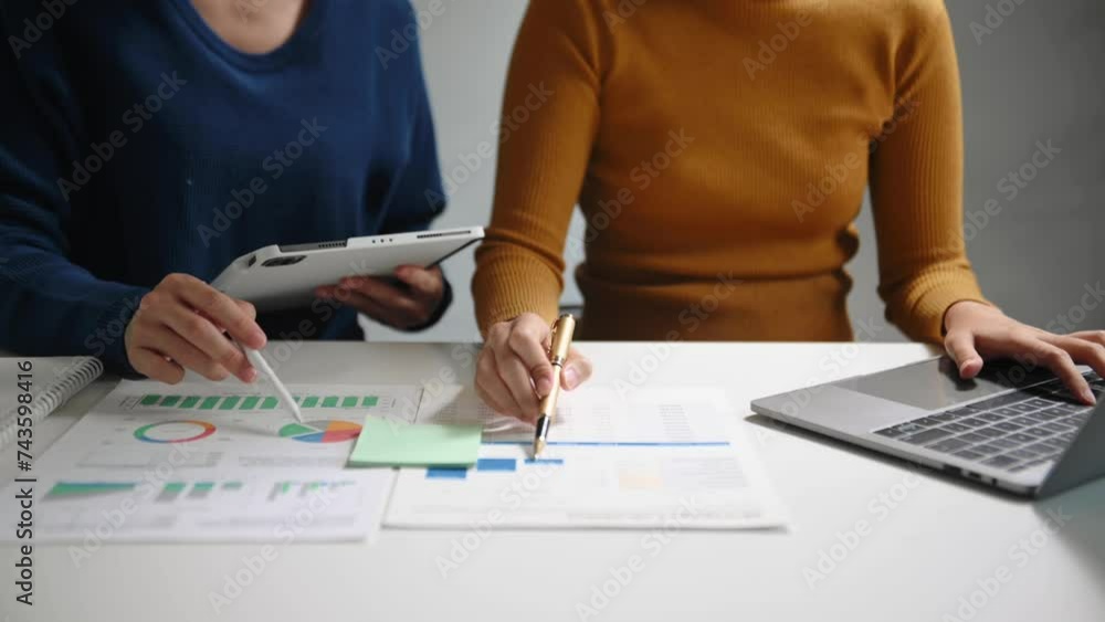 Business documents on office table with smart phone and calculator digital tablet and graph business with social network diagram and two colleagues discussing data working Business documents on office table with smart phone and calculator digital tablet and graph business with social network diagram and two colleagues discussing data working