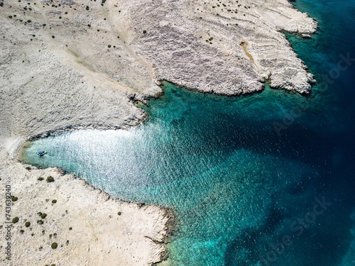 Pag Island coastline with a boat in the cove near Jadra Beach, Stara Novalja and Zigljen, Croatia and the beautiful blue Adriatic sea photo