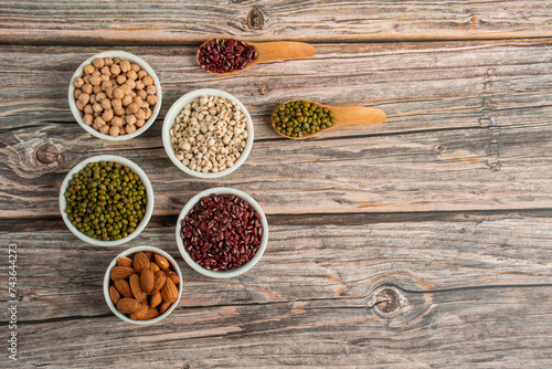 Mung beans, Red kidney beans, Chickpeas source and peeled barley in white cup on spoon wooden on wood background