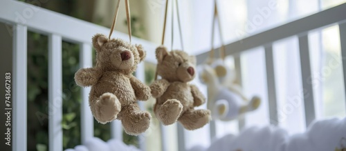 Suspension of cute toy teddy bears over the portable baby crib. photo