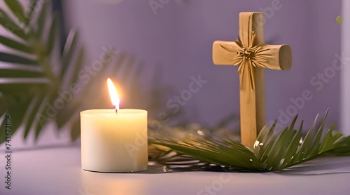 wooden cross, a candle, and palm leaves artfully arranged on a purple background