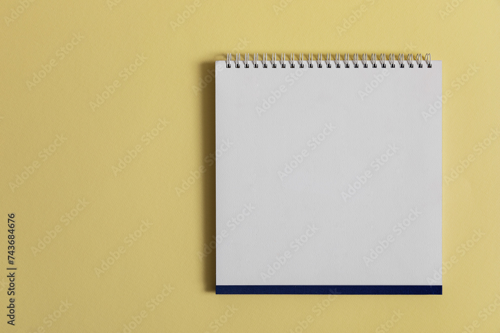 Blank paper desk spiral calendar on yellow background Blank paper desk spiral calendar on yellow background