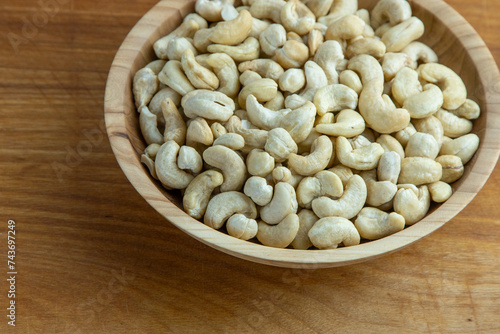 Cashews in a wooden bowl. Nuts are healthy food. Wooden background. Cashew kernel