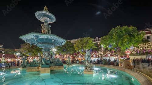 Panorama showing illuminated fountain with holiday decorations at the Rossio Christmas Market timelapse on Dom Pedro IV square. Lisbon, Portugal