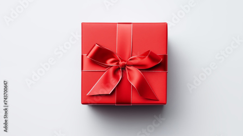 Red gift box shiny satin red bow and ribbon with shadow on white background, close up top view festive illustration. Celebrate decoration element. Birthday or anniversary present