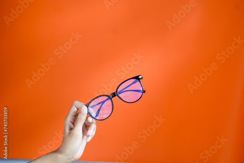 Insulated glasses with black frames. The background is orange