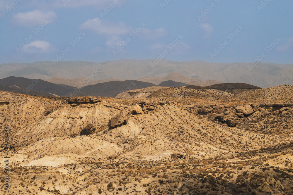 Paisaje desértico en las cercanías de Tabernas, Almería, España. Paisaje árido constituido por colinas y profundos barrancos con escasa vegetación. Día nublado de verano.