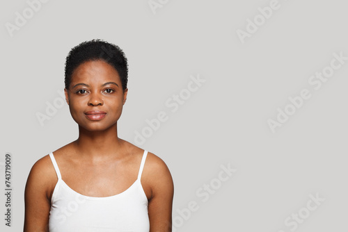 Perfect healthy young woman with dark shiny skin smiling looking at camera on white background. Cosmetology, skincare, facial treatment concept