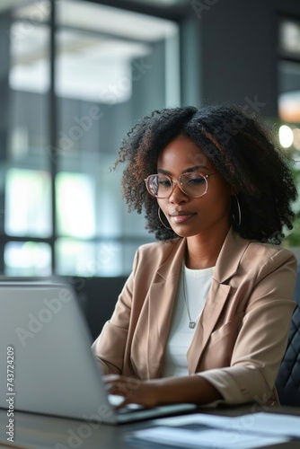 Young busy professional African American business woman working with corporate data on laptop in office, female company marketing manager executive using computer technology, Generative AI