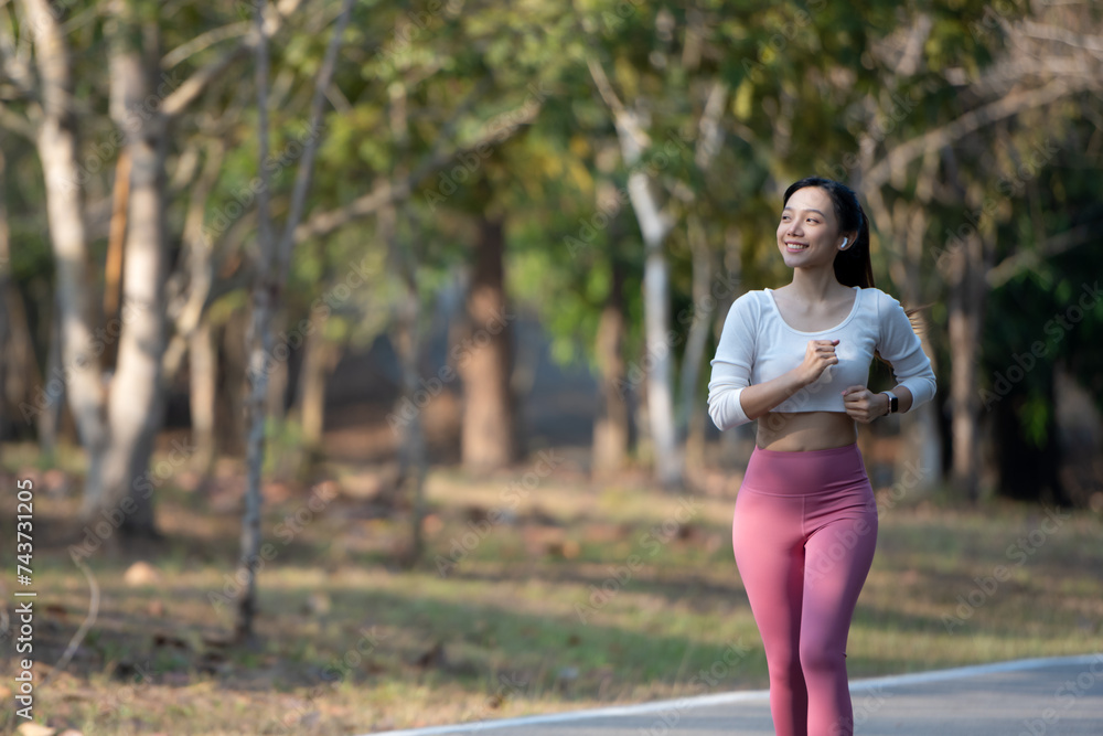 Cheerful woman enjoys jogging on the street in the warm morning sun. Cheerful woman enjoys jogging on the street in the warm morning sun.