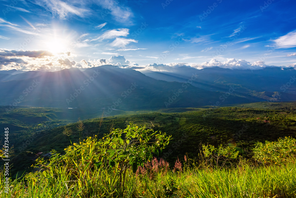Fototapeta premium Sunset view from the most known El Camino Real trail in Barichara, Colombia. The trail is surrounded by lush greenery and offers stunning views of the surrounding hills of Andes mountains.
