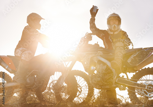 Sport, racer or people on motorcycle outdoor on dirt road and relax after driving, challenge or competition. Lens flare, motorbike or dirtbike driver and sunrise on offroad course or path for racing